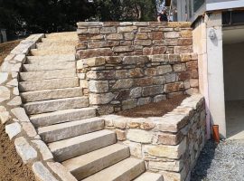Natursteinmauer mit Blockstufen aus Gneis in einer Gartenanlage mit Hanglage