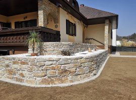 Terrassengestaltung mit Natursteinmauer aus Gneis bei einem Einfamilienhaus